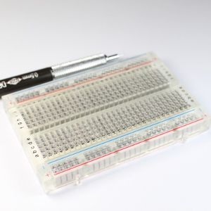 Clear transparent breadboard with 30 tie strips on each side (60 tie strips) and two power rail on each side.